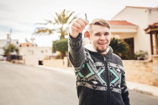 Happy smiling man showing a keys of his new house.