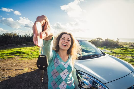 Young Happy Smiling Woman Showing The Key Of New Car.