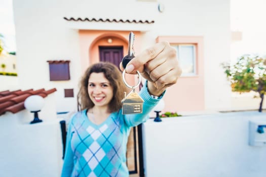 Beautiful caucasian woman holding keys of new house.