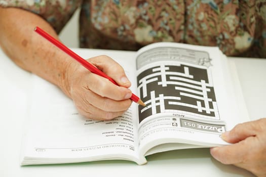 Bangkok, Thailand - May 15, 2022 elderly woman playing sudoku puzzle game for treatment dementia prevention and Alzheimer disease.