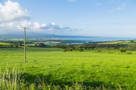 Stunning view over countryside, fields, hills and the sea near Dungarvan, Ireland.