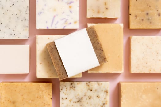 Beige and brown handmade soap bars on light pink top view, soap packaging mockup, copy space. Natural herbal products for for face and body care. Using organic handmade skincare products