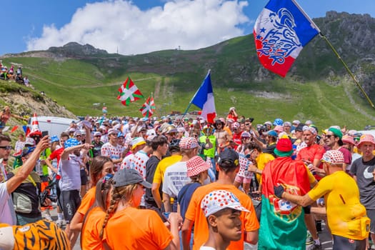 Col du Tourmalet, France - July 06 2023: Cycling fans waiting for the buch at the top of the Col du Tourmalet in Pyerenees mountains during the stage 6 of Le Tour de France 2023