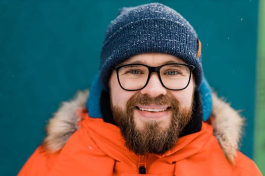 Close-up portrait of a bearded man with a beard. Snow and winter season.