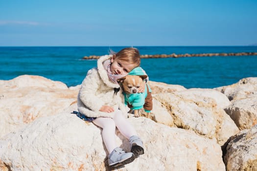 Little girl with chihuahua dog, outdoor summer.