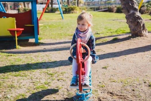 summer, childhood, leisure and people concept - happy little girl on children playground.