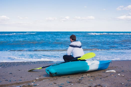 Man with kayak on the beach in sunny day.