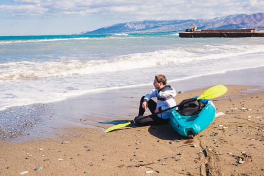 Man with kayak on the beach in sunny day.