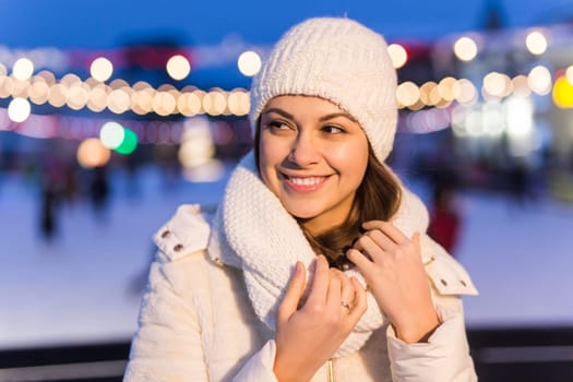 Happy young woman in winter on the ice rink taking picture on smartphone.