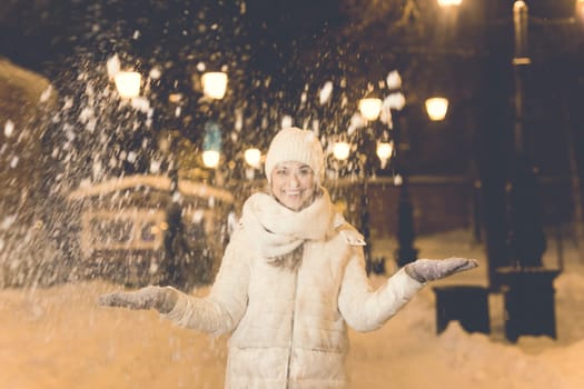 Girl in a night city snowflake Christmas city lights. Christmas and winter holidays.