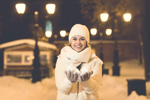 Girl in a night city snowflake Christmas city lights. Christmas and winter holidays.