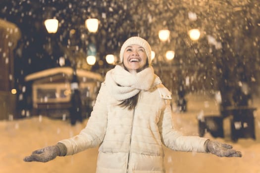 Girl in a night city snowflake Christmas city lights. Christmas and winter holidays.