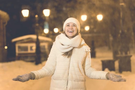 Girl in a night city snowflake Christmas city lights. Christmas and winter holidays.