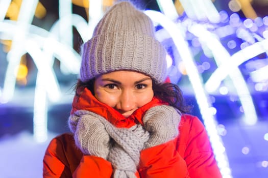 Portrait of young funny attractive woman over snowy Christmas background. Winter holidays and season.
