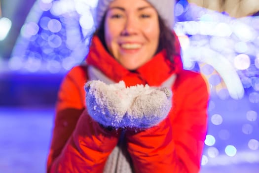 Winter holiday season. Christmas, New Year concept. Funny woman spend time having fun near illuminated and decorated showcase on city street.