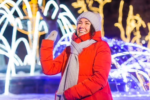 Portrait of young funny attractive woman over snowy Christmas background. Winter holidays and season.