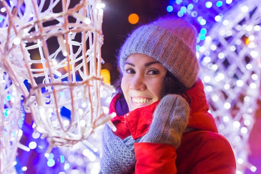 Portrait of young funny attractive woman over snowy Christmas background. Winter holidays and season.