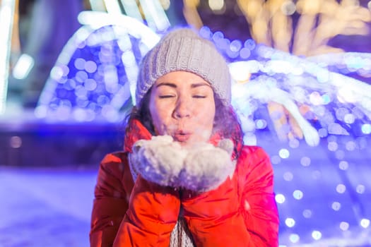 Portrait of young funny attractive woman over snowy Christmas background. Winter holidays and season.