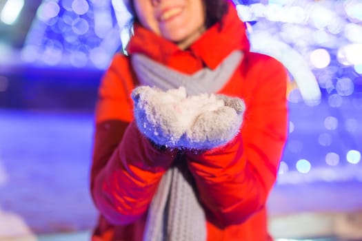 Portrait of young funny attractive woman over snowy Christmas background. Winter holidays and season.