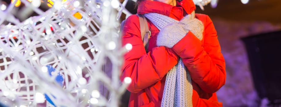 Girl in a night city snowflake Christmas city lights. Christmas and winter holidays.