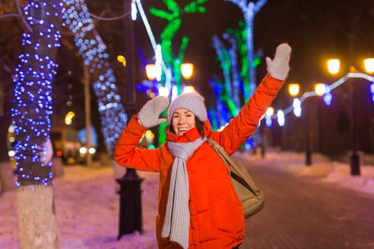 Girl in a night city snowflake Christmas city lights. Christmas and winter holidays.