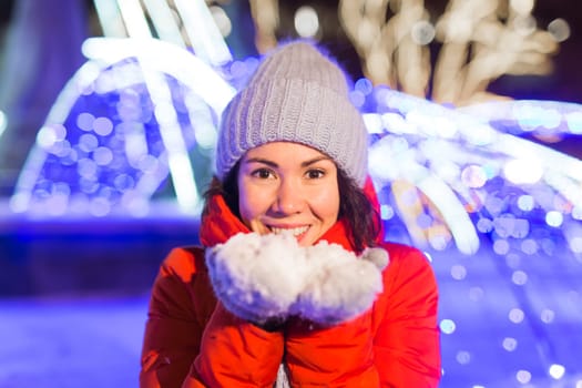 Girl in a night city snowflake Christmas city lights. Christmas and winter holidays.