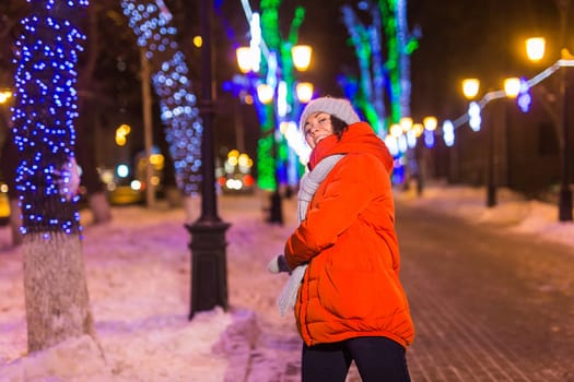 Portrait of young funny attractive woman over snowy Christmas background. Winter holidays and season.