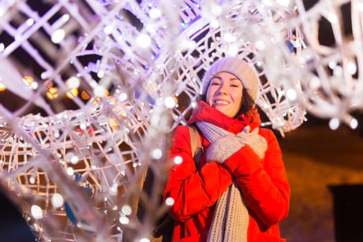Portrait of young funny attractive woman over snowy Christmas background. Winter holidays and season.