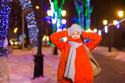 Portrait of young funny attractive woman over snowy Christmas background. Winter holidays and season.