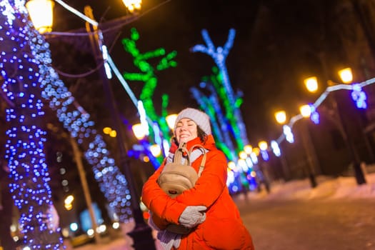 Portrait of young funny attractive woman over snowy Christmas background. Winter holidays and season.