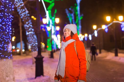 Girl in a night city snowflake Christmas city lights. Christmas and winter holidays.