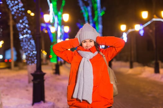 Portrait of young funny attractive woman over snowy Christmas background. Winter holidays and season.