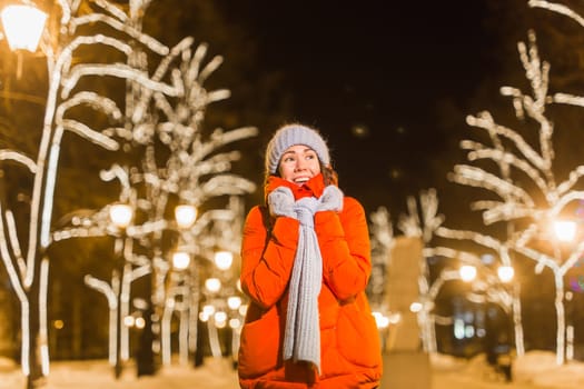 Portrait of young funny attractive woman over snowy Christmas background. Winter holidays and season.