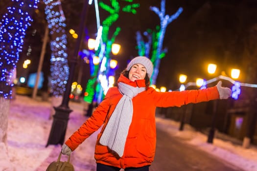 Girl in a night city snowflake Christmas city lights. Christmas and winter holidays.