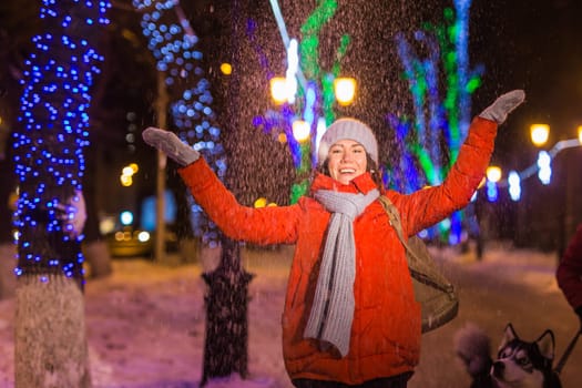 Portrait of young funny attractive woman over snowy Christmas background. Winter holidays and season.