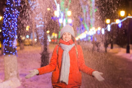 Girl in a night city snowflake Christmas city lights. Christmas and winter holidays.