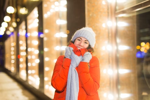 Portrait of young funny attractive woman over snowy Christmas background. Winter holidays and season.