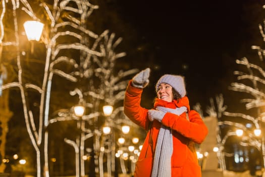 Girl in a night city snowflake Christmas city lights. Christmas and winter holidays.