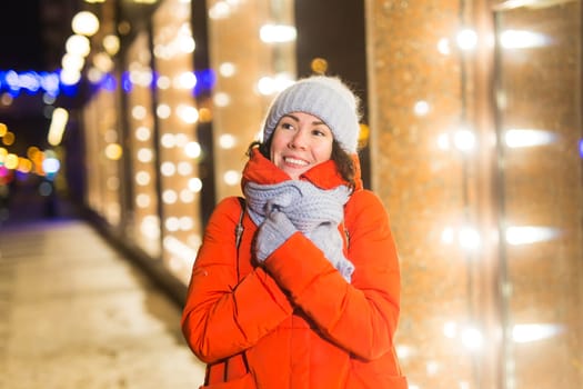 Girl in a night city snowflake Christmas city lights. Christmas and winter holidays.