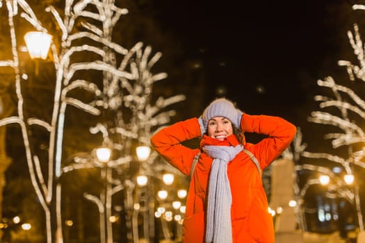 Portrait of young funny attractive woman over snowy Christmas background. Winter holidays and season.