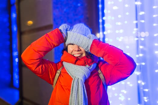 Girl in a night city snowflake Christmas city lights. Christmas and winter holidays.
