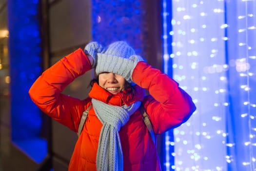 Girl in a night city snowflake Christmas city lights. Christmas and winter holidays.