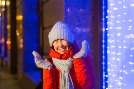 Portrait of young funny attractive woman over snowy Christmas background. Winter holidays and season.