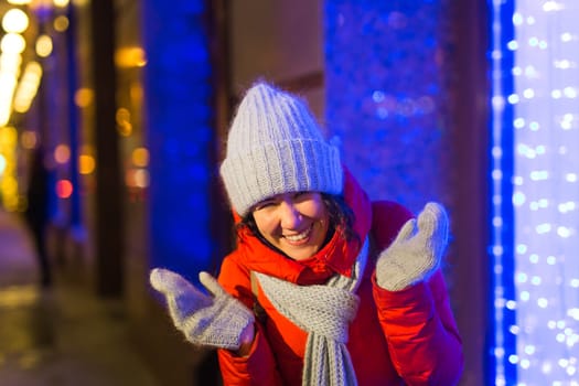 Girl in a night city snowflake Christmas city lights. Christmas and winter holidays.