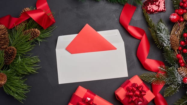 Christmas decor, gifts wrapped in red paper and a letter on a black background, top view