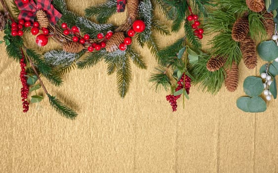 Christmas wreath made of fir branches and other decorations on a yellow background, copy space