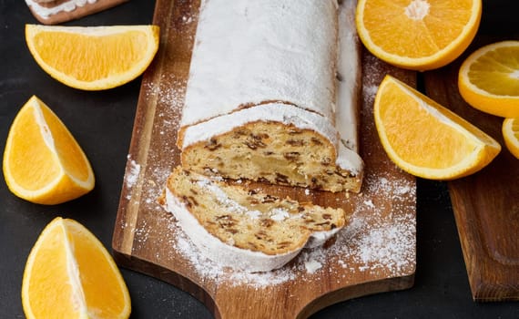 Christmas pastries stollen sprinkled with powdered sugar on the table, festive dessert
