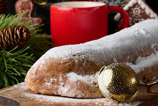 Christmas pastries stollen sprinkled with powdered sugar on the table, festive dessert