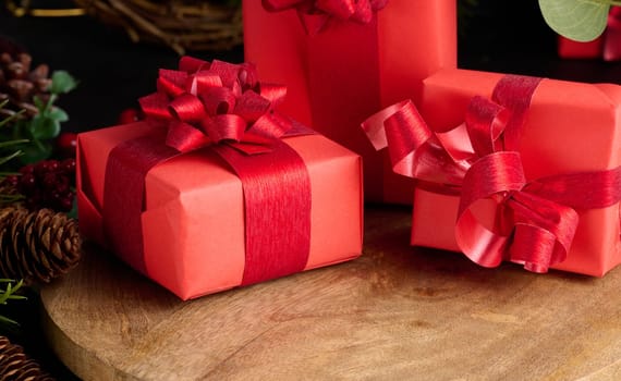 Gift boxes wrapped in red paper against Christmas decor background