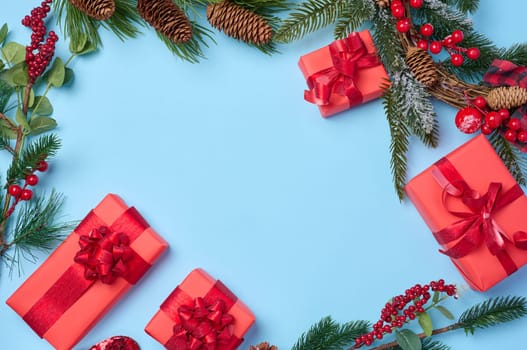 Christmas decor, gifts wrapped in red paper on a blue background, top view. Copy space